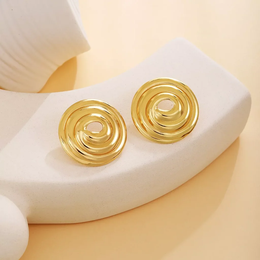 A pair of spiral gold stainless steel earrings with a glossy finish, designed for modern fashion wholesale collections.