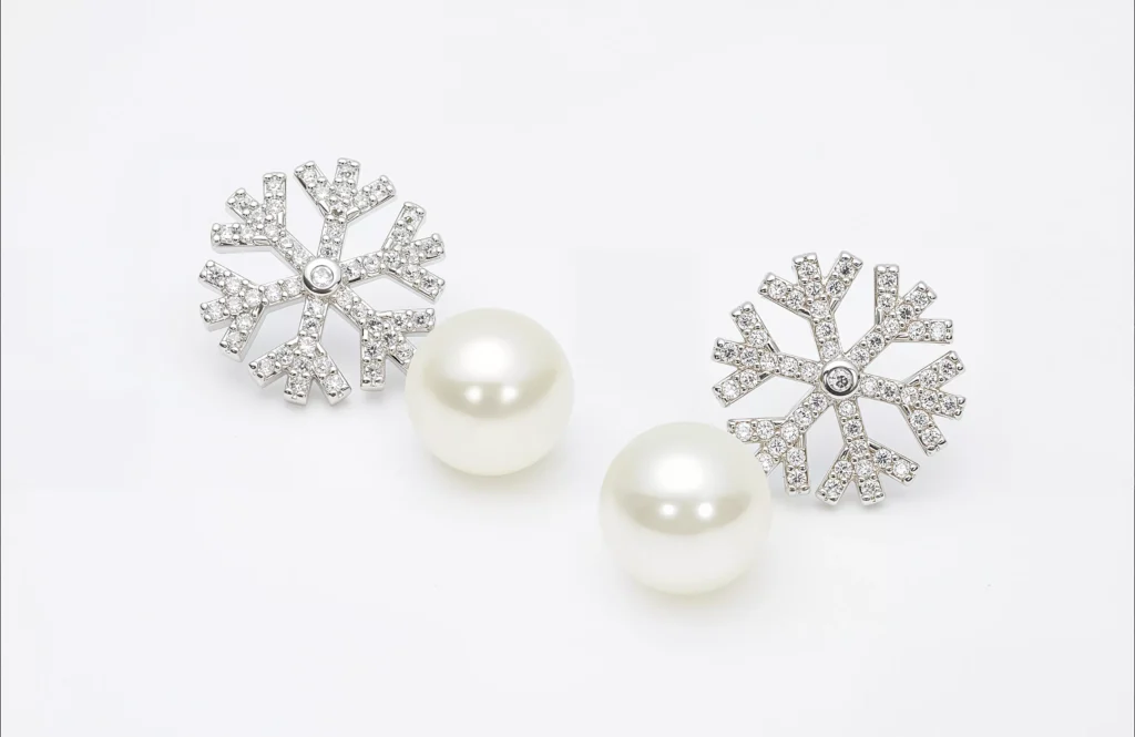 Close-up of elegant snowflake pearl stud earrings made of stainless steel with crystal accents, displayed on a white background – ideal for wholesale buyers from a trusted stainless steel jewelry supplier